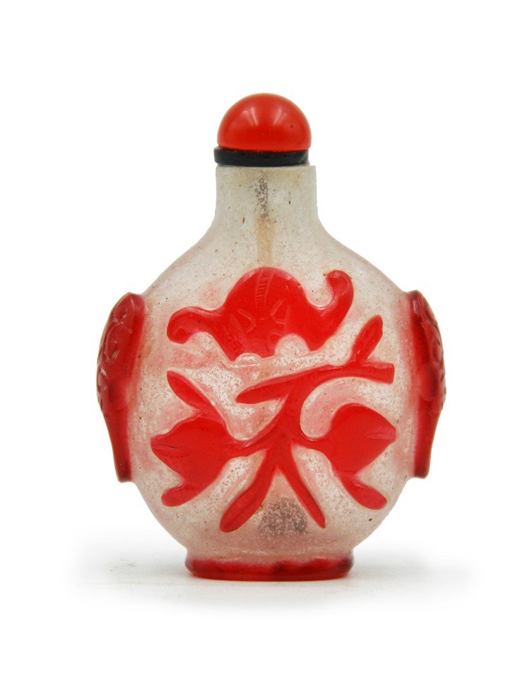 GLASS SNUFF BOTTLE: Simple and eye-catching due to the simple color combination of milky white and bright red, this glass snuff bottle is topped with a matching red stopper. The carving presents traditional Chinese symbo