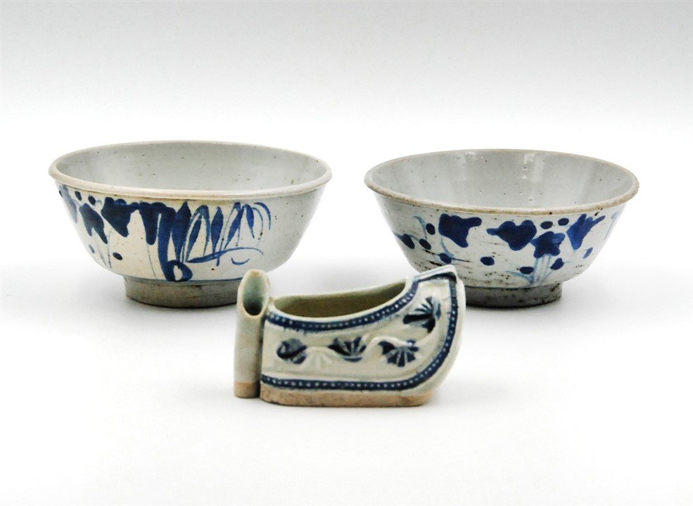 MING DYNASTY BLUE AND WHITE PORCELAIN SET OF THREE: Dating back to Ming Dynasty (1368-1644), this set comprises a pair of blue and white porcelain bowls, decorated with Chinese ink wash paintings, and a shoe-shaped porcelain sculpture, decorated with f