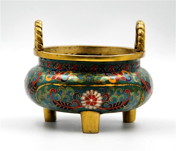 CLOSONNE INCENSE BURNER: This squat round tripod incense burner has dark gold-toned handles and feet. Overall the body has been covered in a blue enamel, and floral patterns in red, yellow, green, and black.D:5 H:3.5