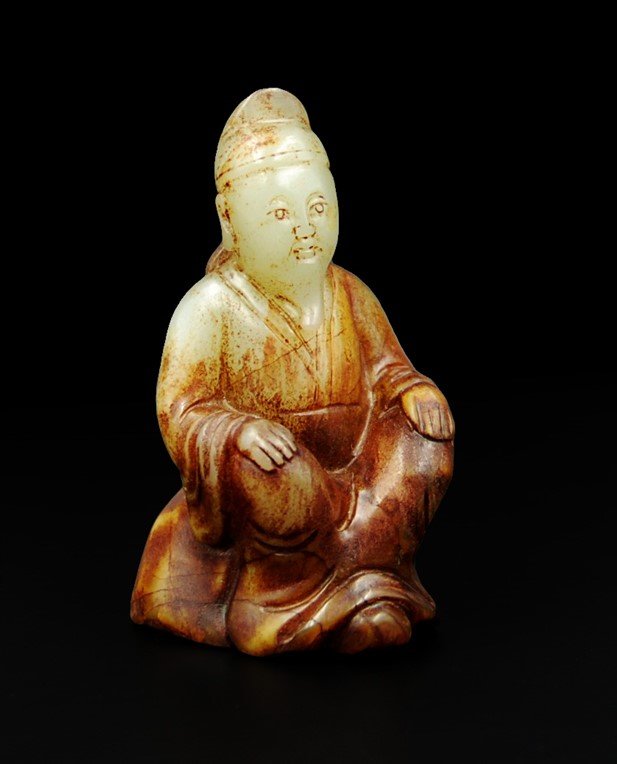 NEPHRITE MAN AT REST: A very fine piece of nephrite (He Tian Yu) carved into a shape of a contemplating Chinese poet. He is sitting with crossing legs, with hands on both of his laps. Natural coloration goes from rusty red