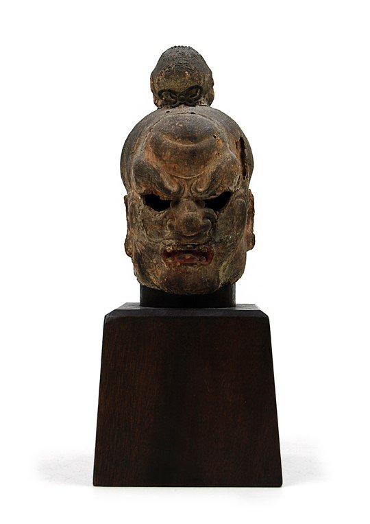 CARVED KAMAKURA (1186- 1333) HEAD: A carved wooden guardian head mounted on a customized wooden stand.