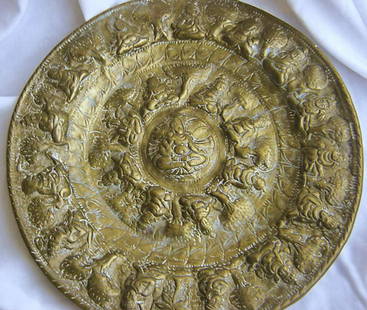 Older Hindu plaque of repousse brass --10.75" in: Older Hindu plaque of repousse brass --10.75" in diameter. Significant wear.