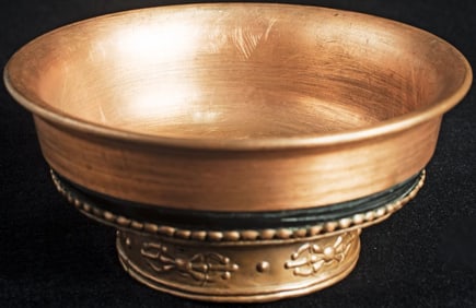 Old Mongolian copper ritual bowl with elaborate detail.