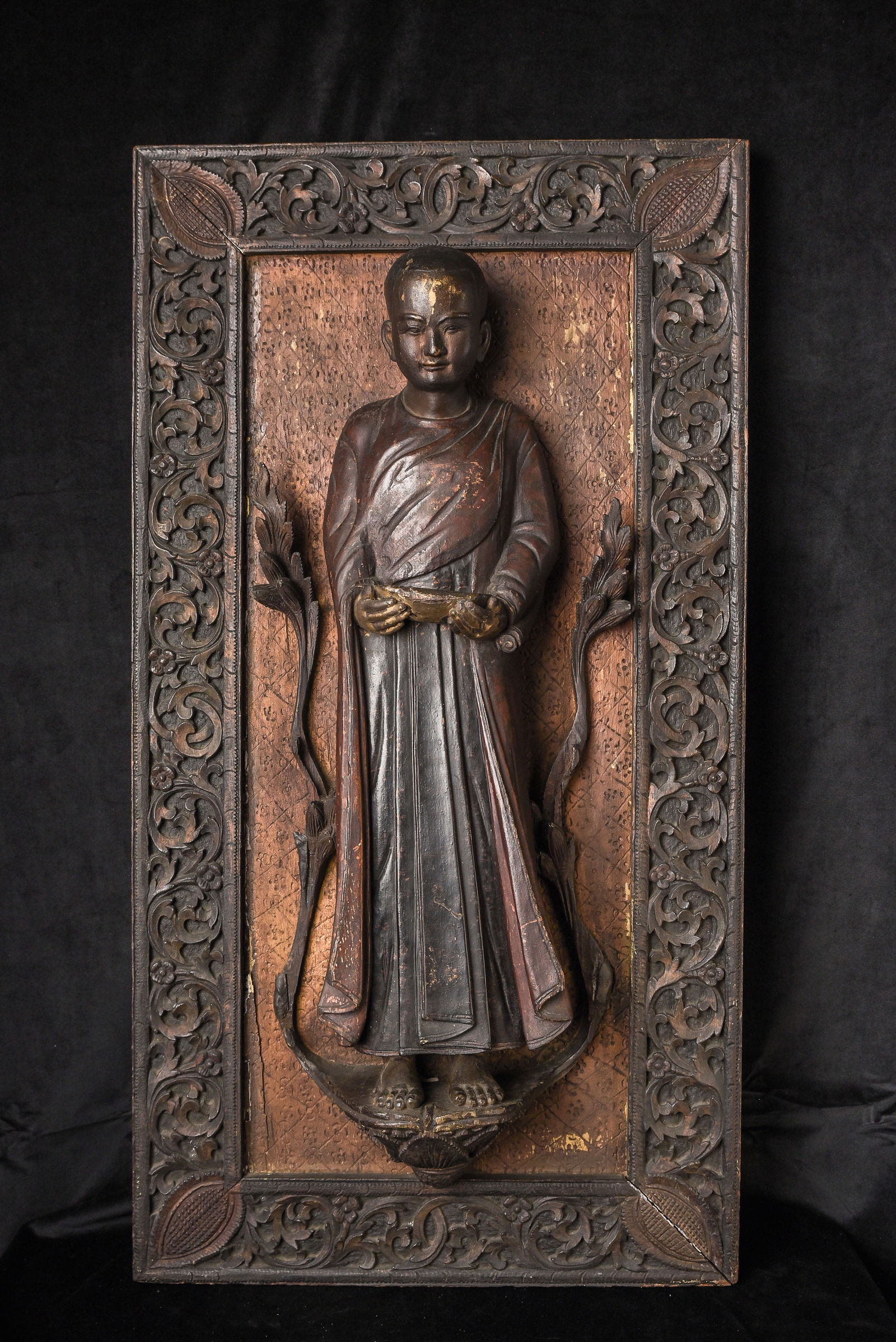 18th Century Large Burmese Carved Monk Panel from Temple Wall: This large and impressive carved panel dates to the 18th century and depicts a standing Burmese monk, most likely originally installed as part of a temple wall or architectural setting. The figure is