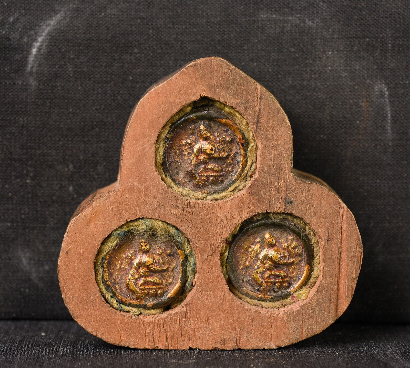 Three small old Mongolian tsa tsa's in a very provincial recent wooden gau.: Three small old Mongolian tsa tsa's in a very provincial recent wooden gau. ( 2.375" H x 2.5"W x .75"D ) - 25g.