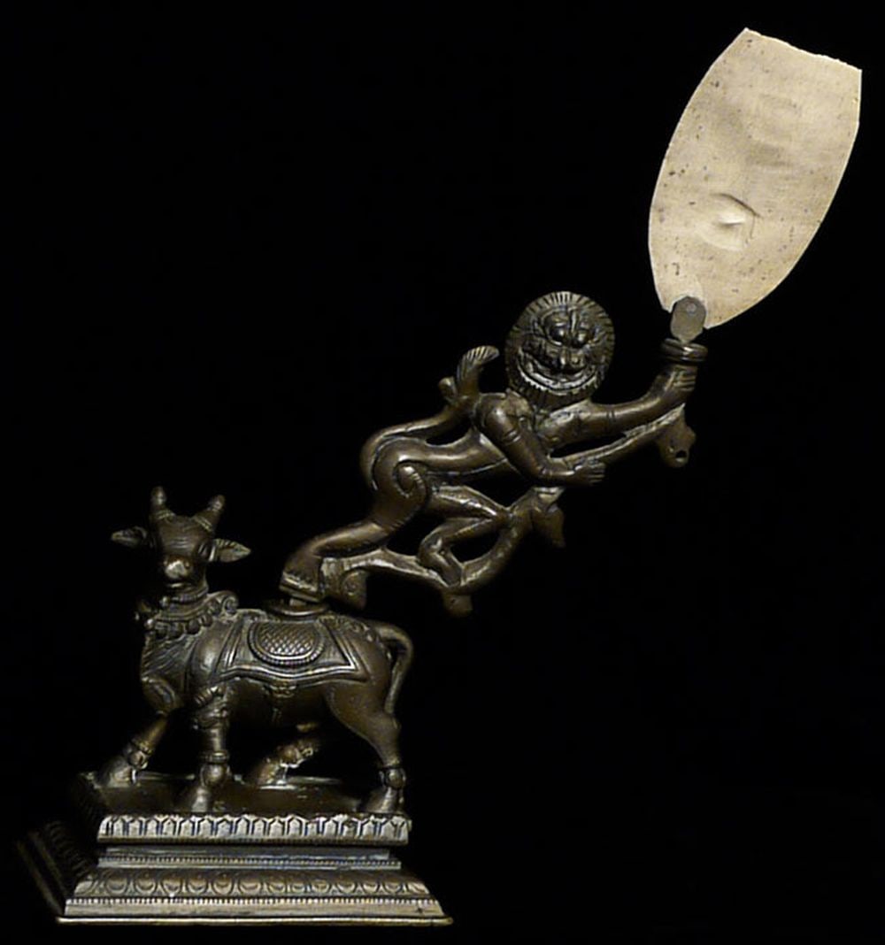Very unusual bronze lion on cow. Loss of top of object: Very unusual bronze lion on cow. Loss of top of object in lion's hands- otherwise in super condition. Height to top of paddle is 8.75". Base measures 3 7/8" x 2 5/8".