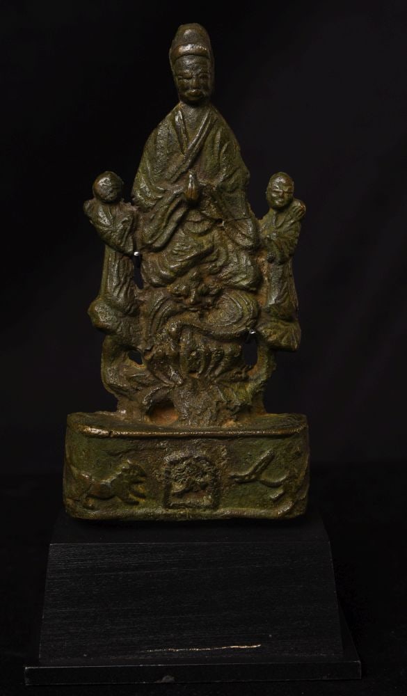 Very early Chinese bronze Buddha with attendants. 9009: Early Chinese bronze Buddha with attendants. Bronze alone stands 6 1/8 inches tall, 3 inches wide, height on custom base is 8 1/8 inches. There is worn, indecipherable writing on the backside. I