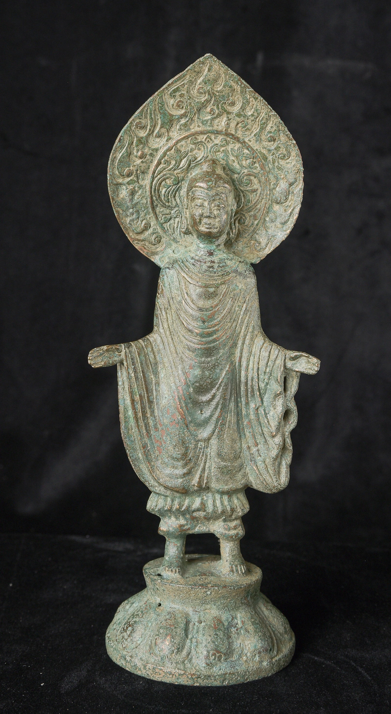 Very early finely rendered Chinese standing bronze Buddha.: Early standing Chinese bronze Buddha. The high level of detail in the robes and halo appear to be created by carving out the detail rather than casting it into the metal. This is a very uncommon and q