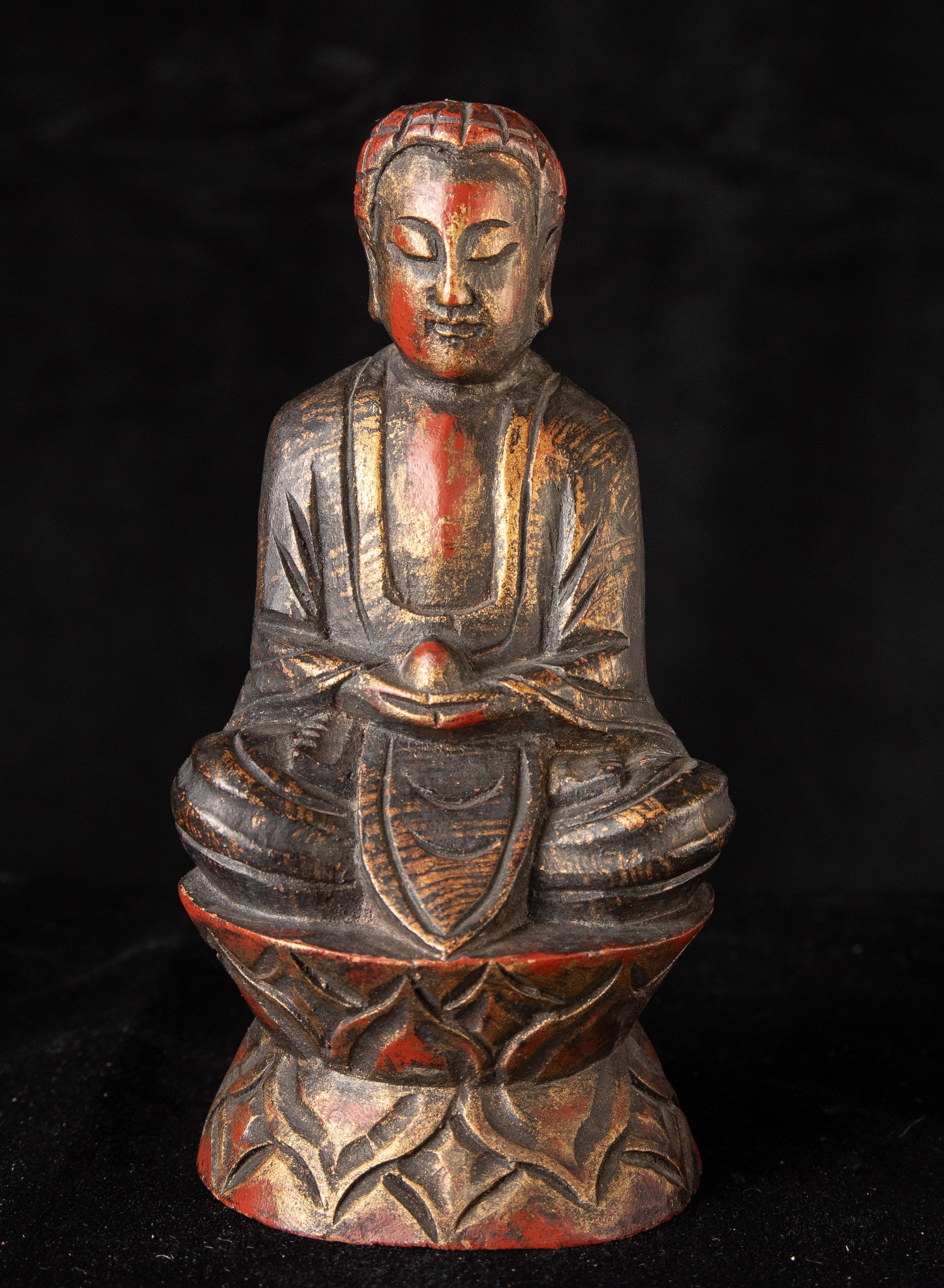 Vintage Hand Carved Chinese Wooden Buddha with Red Lacquer and Gilded Highlights: A finely carved Chinese wood Buddha seated in meditation upon a layered lotus base, retaining beautiful traces of original red pigment and gilded highlights across the surface. The carving has a pleas