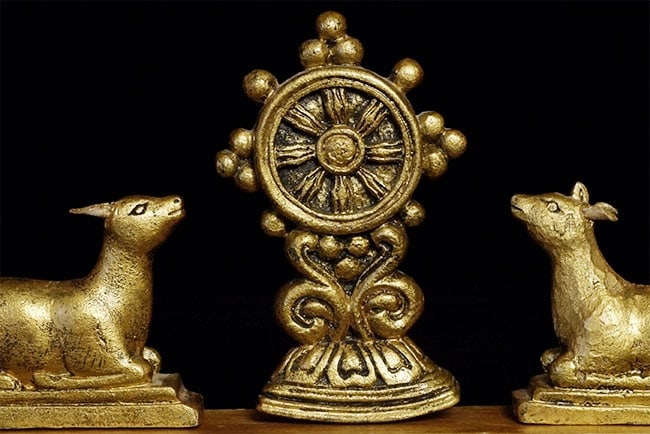 Pair of vintage "wood" Mongolian deer flanking a wheel of the law.: Pair of vintage "wood" Mongolian deer flanking a wheel of the law. Purchased out of Mongolia in the mid 1990's when their country was opening to the west. Deer are 2.5 inches tall, overall dimensions 