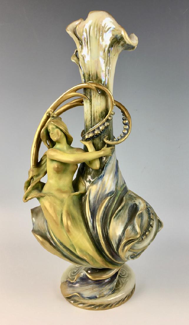 Amphora Art Nouveau Nude Figural Vase: Circa 1890, depicting a nude figural woman sitting on the side of vase surrounded by bellflowers, made of porcelain, signed with RSTK mark with numbers "738 5" and marked "Amphora", very good conditio