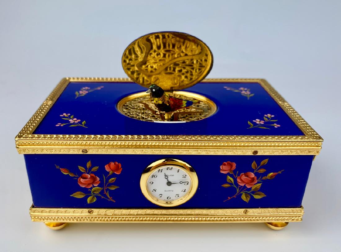 Reuge Enameled Singing Bird Box with Clock: Footed box automaton has gold plated trim, enameled in cobalt blue with flowers, consists of a clock, marked on bottom "Reuge Music-Saint Croix-Made in Switzerland", very good condition, 4.75" x 3" x 