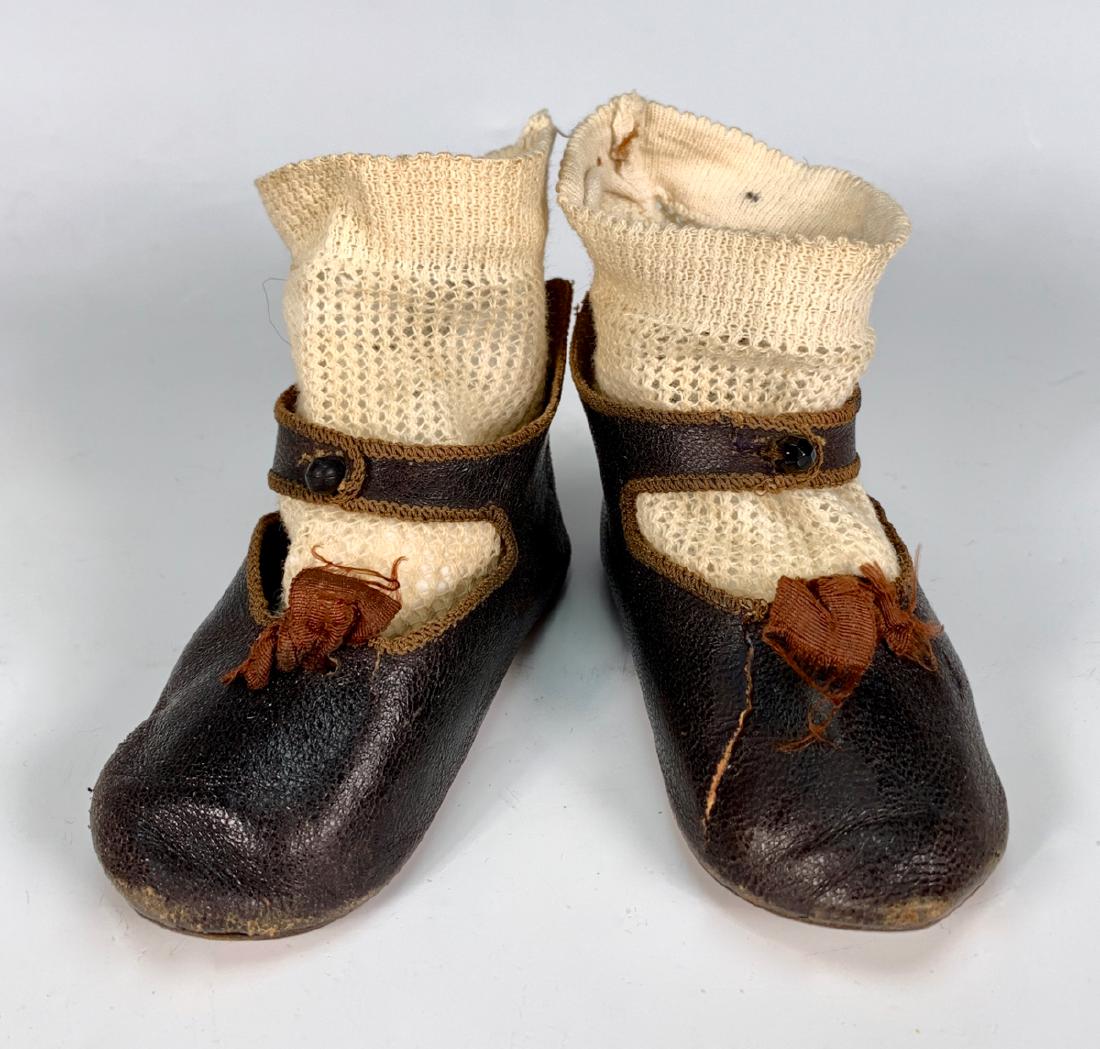 French Jumeau Leather Shoes C. 1882: Stamped "Paris Depose" with bee symbol, one tear repaired towards front of shoe, crocheted antique socks, very good condition, size 12, 4.125" x 1.625"