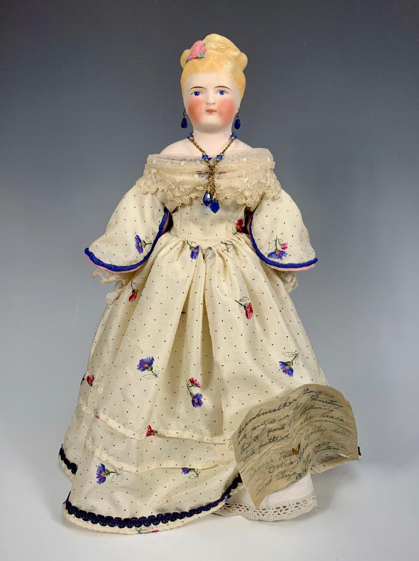 German Parian C. 1860's: Blue painted eyes, fancy blond hairdo up in bun with molded rose, pierced ears, bisque arms repainted and possibly repaired, left thumb broken, shoulder plate repaired and repainted, written note of p