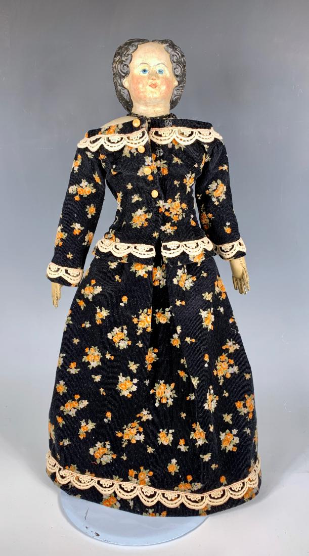 German Papier Mache Grenier Type Doll C. 1850: Blue painted eyes, substantial touchup to face, hair has original paint, small amount of typical crazing on head and shoulder plate, older cloth body with leather arms, original Greiner label on botto