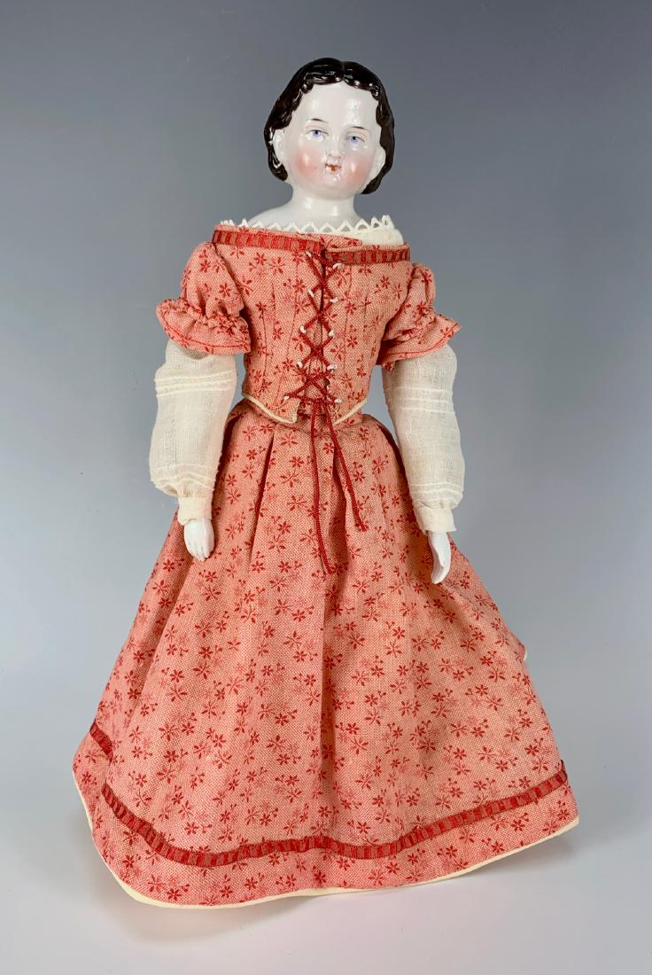 German China Blue Eyed Doll C. 1860's: Beautifully molded face, blued painted eyes, exposed ears, cloth body, china arms and lower legs with molded black boots, paint rub on both feet, chip on end of right toe, all clothing made with old f