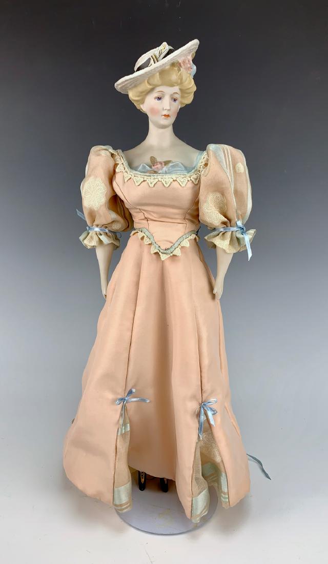 Emma Clear "Gibson Girl" Parian: C. mid 20th century, blue painted eyes, molded blond Gibson hairdo with molded hat, molded and painted black lace-up boots, cloth body, parian lower arms, all clothing made of old fabric, very good co