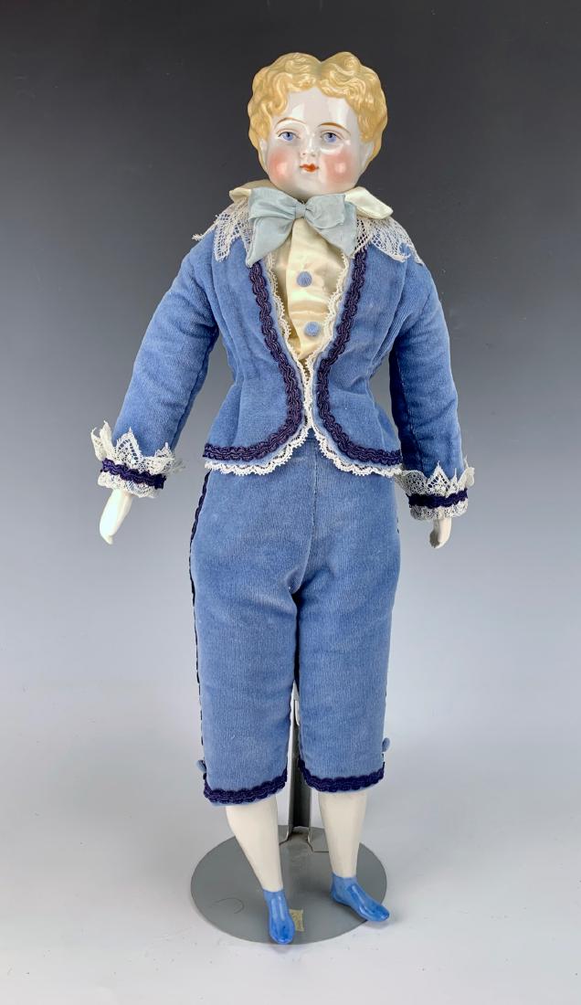 German Boy Shoulder Head Doll C. 1880's: Blue painted eyes, repaired shoulder plate, china lower arms and legs, painted blue short boots, some scuffs on back of hair, clothing made of new fabric, fair condition, 17.5"