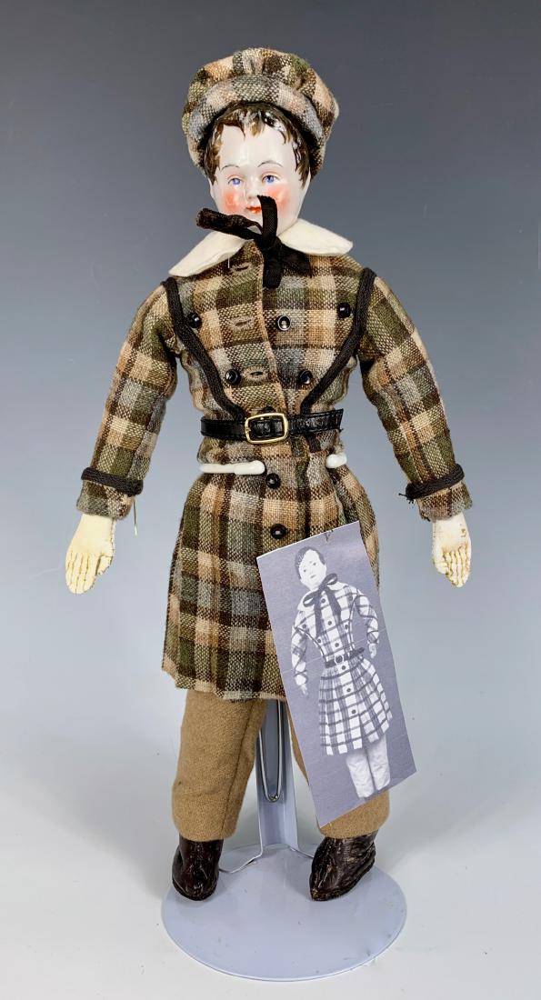 Early German China Young Man Doll C. 1840: Blue painted eyes, brown hair, wispy bangs and sideburns, exposed ears, cheek rubs and several pepper spots, ungusseted leather body, leather heeled boots, expertly made wool costume and cap of old fa