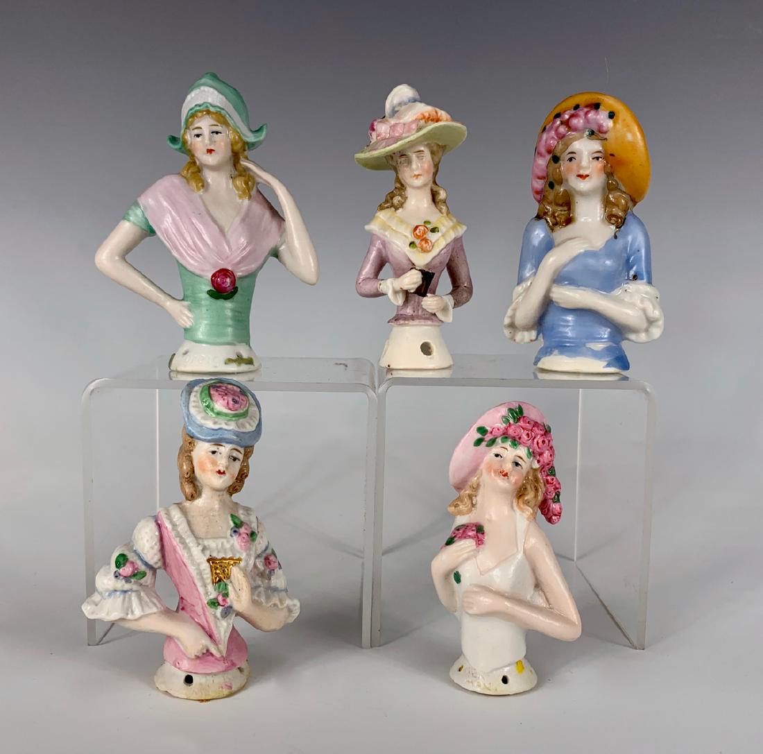 5 German Porcelain China Half Dolls C. 1920's: Ranging from 3" to 3.25", all with fancy molded hats, orange bonnet head marked "Japan", three marked "Germany", doll with violet hat unmarked, good condition