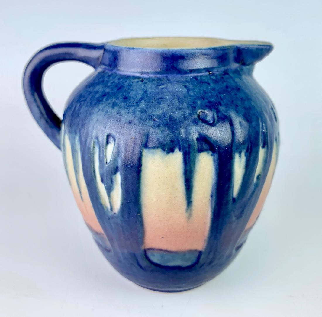 Newcomb College Art Pottery Pitcher: Decorated by Sadie Irving with unusual design of moss laden trees at sunset, matte glaze with blue, pink and yellow, base marked with Newcomb cipher, decorators mark, Jonathan Hunt potters mark and Sa
