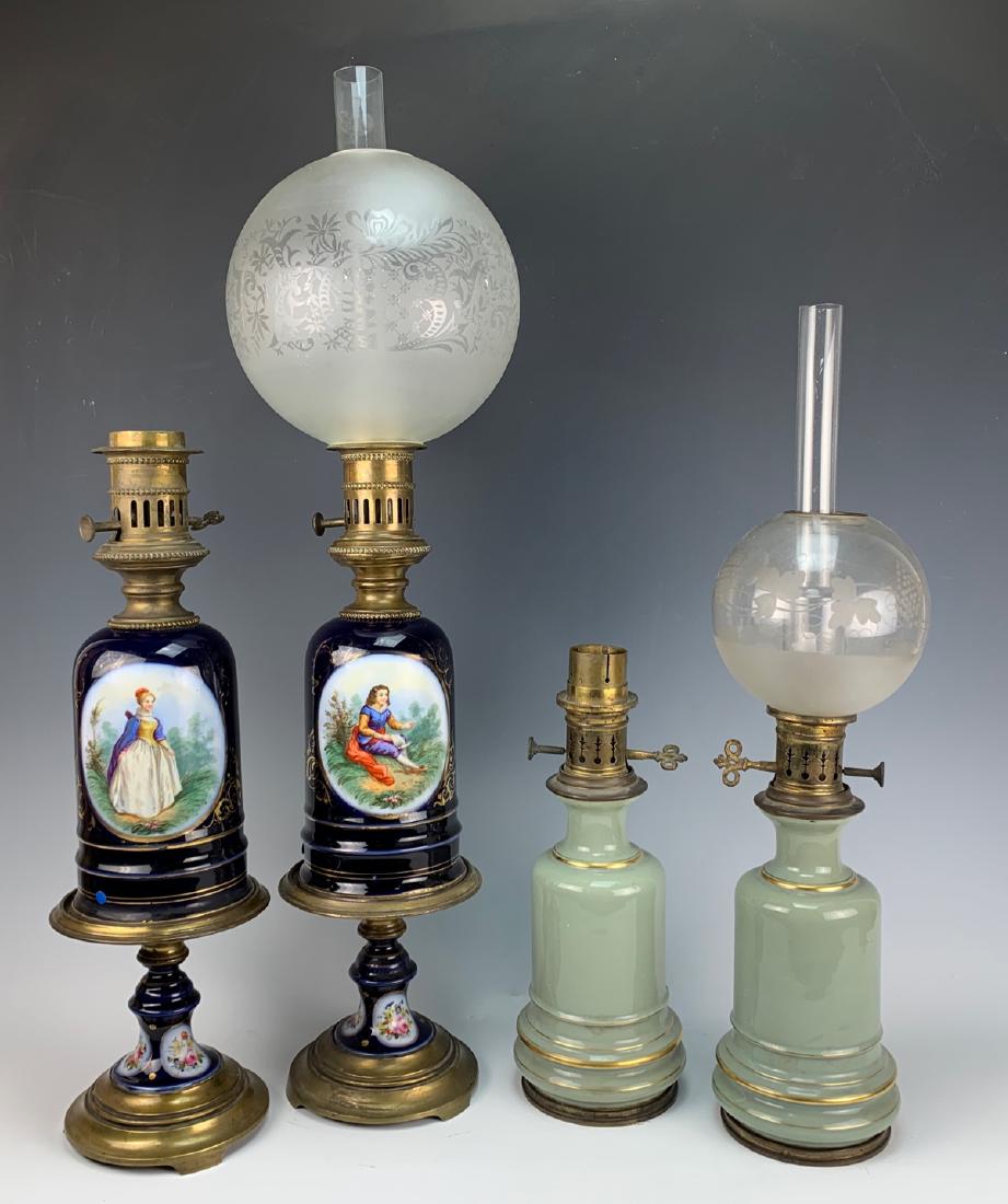 2 Pairs of 19th Century Oil Lamps: First pair are cobalt blue porcelain with oval hand painted scenes of a man and woman mounted in bronze metal mounts, other pair are celadon porcelain with bronze mounts, each pair has one missing one
