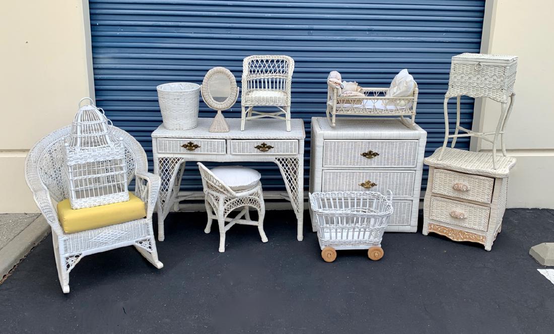 12 Pieces of Wicker Furniture & Accessories: Offering just in time for the summer! This collection of 12 pieces of wicker, consisting of chest of drawers with glass top, vanity table with chair, rocking chair, 2 drawer stand, bird cage, vanity m