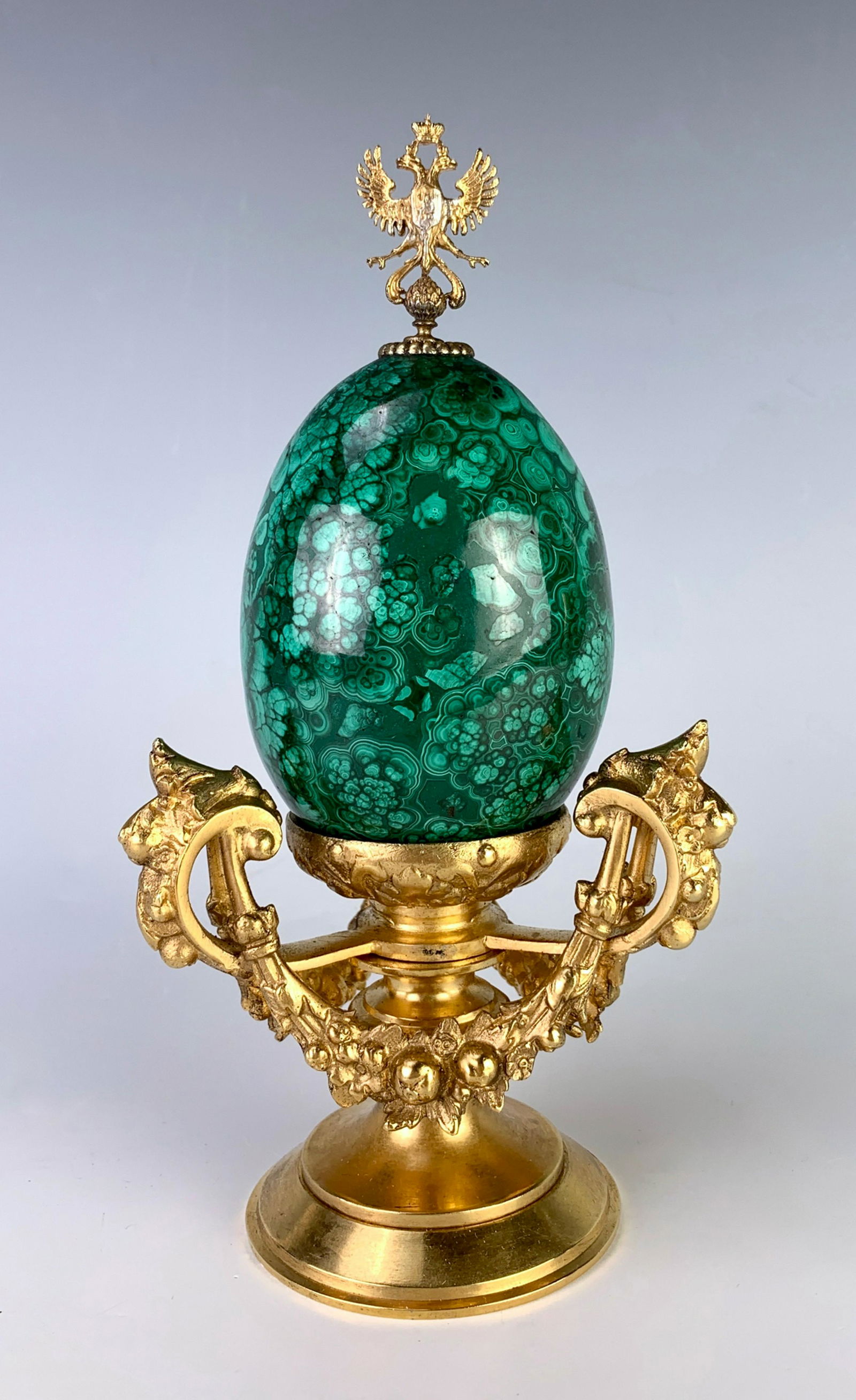 Russian Dore Bronze & Malachite Easter Egg: Having a dore bronze holder with 3 floral swags, malachite easter egg with dore bronze Russian double wing eagle finial, very good condition, 7.75" height, 3.5" egg height only