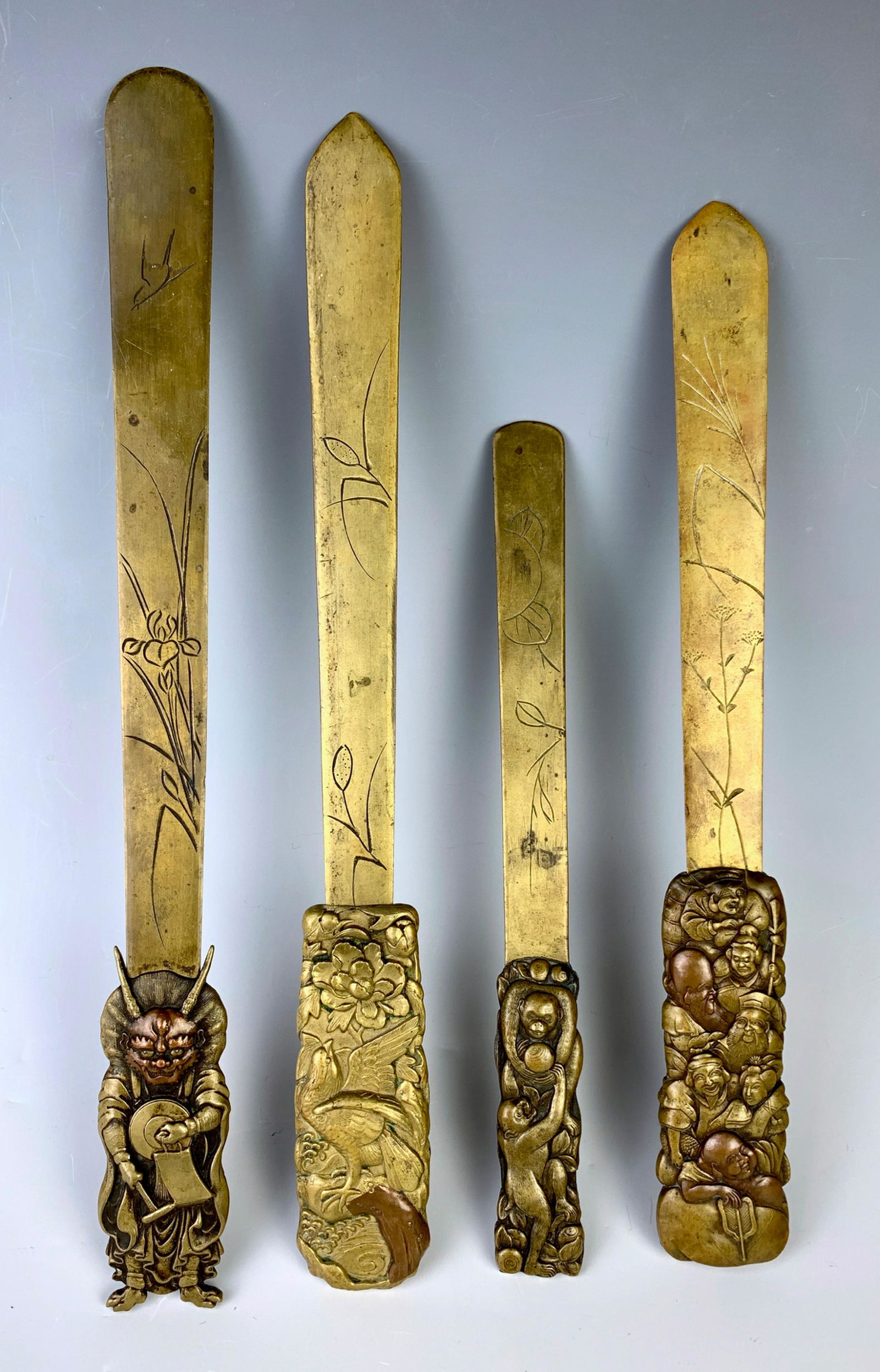 4 Japanese Antique Page Turners Meiji Period: Part of a collection consisting of 4 Japanese page turners, one having monkeys playing, one Omi devil made of mixed metal, one bird on a branch, and group of men and women made of mixed metal, very go