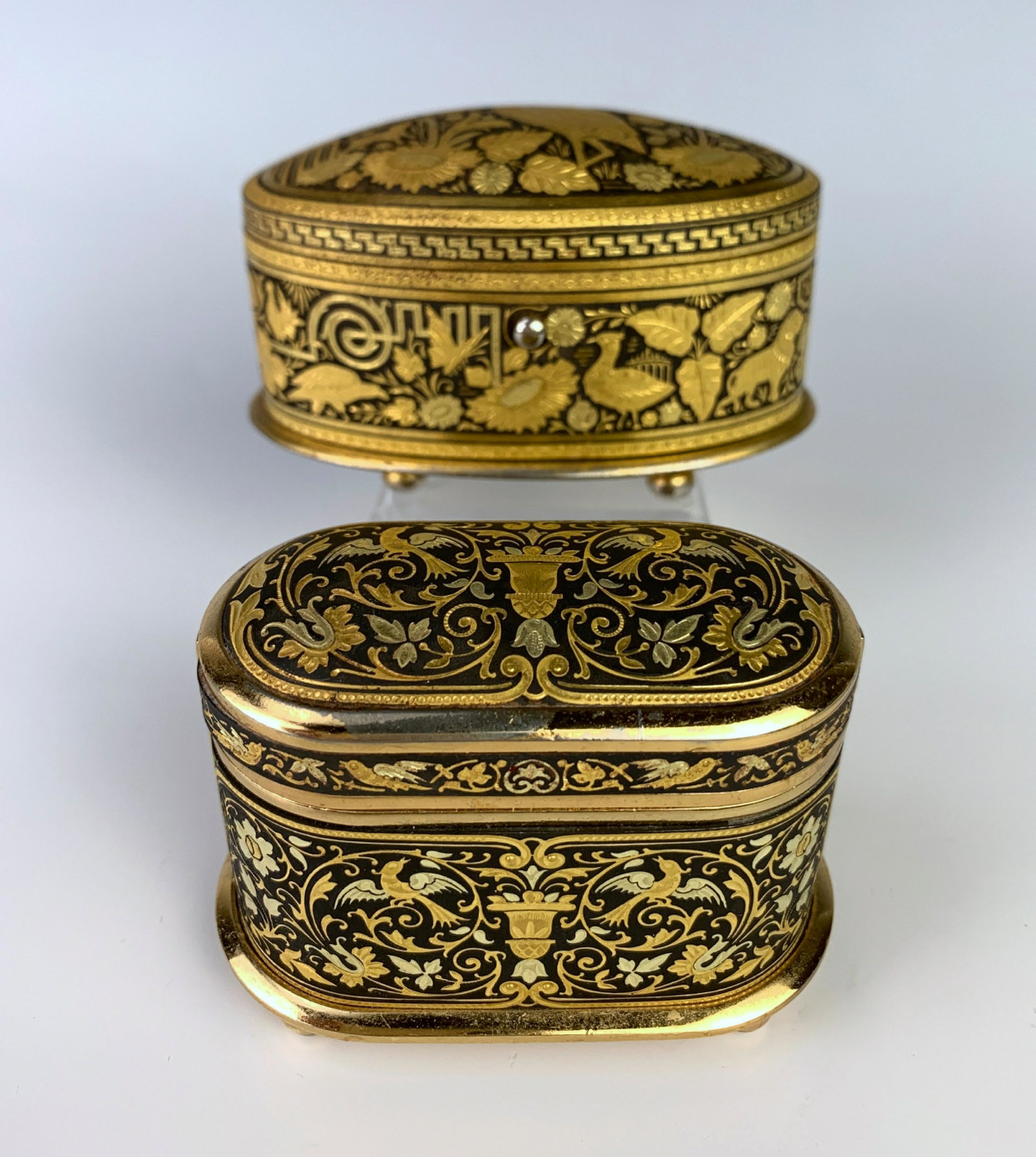 Pair of Damascene (Toledo) Metalwork Boxes: Having a pair of exquisite quality Damascene metalwork oval boxes, both encrusted within gold and silver on iron, one with the mark of "Midas of Toledo Spain", both with red velvet interiors, very goo