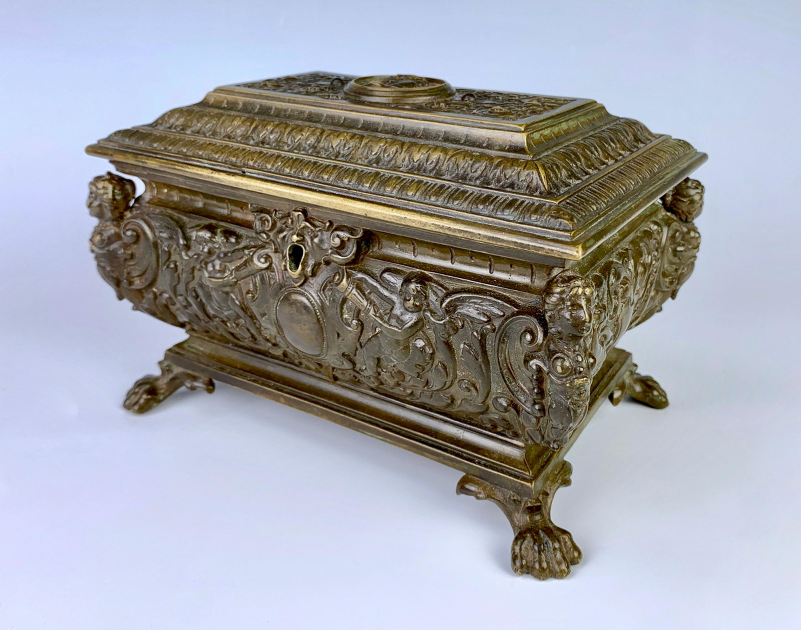 Antique Bronze Raised Relief Box C. 1900: A handsome French bronze patina box depicting scenes of a round lady portrait on top, Medusa face on front, each corner has a figural lady and sits on 4 claw feet, tapestry interior, has mark of a pen