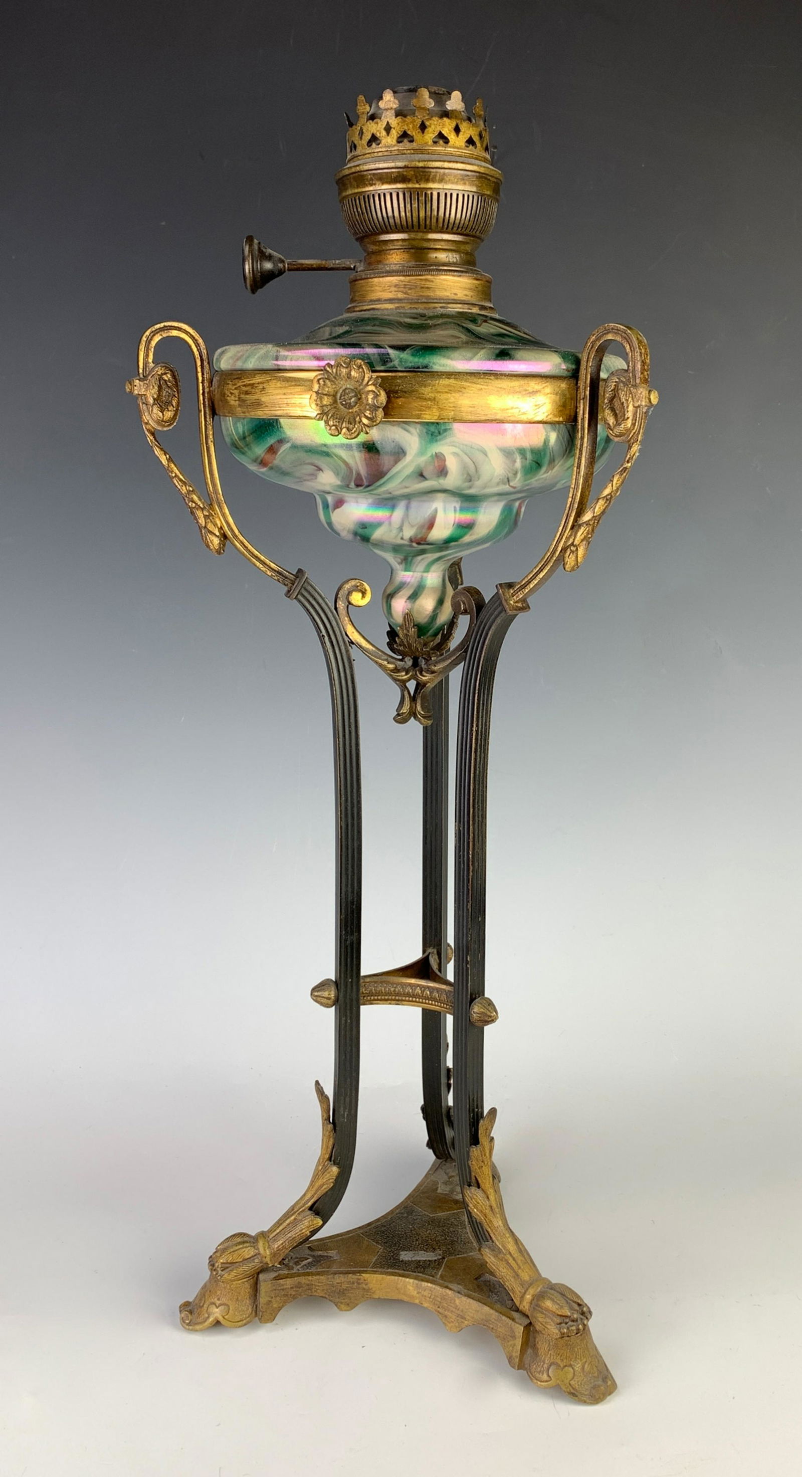 Loetz Type Oil Lamp, Matador Lamps: Early lamp has a marbled iridescent glass font, mounted in a brown and iron 3 legged support, marked "Matador" a German lamp company, very good condition, 21" height