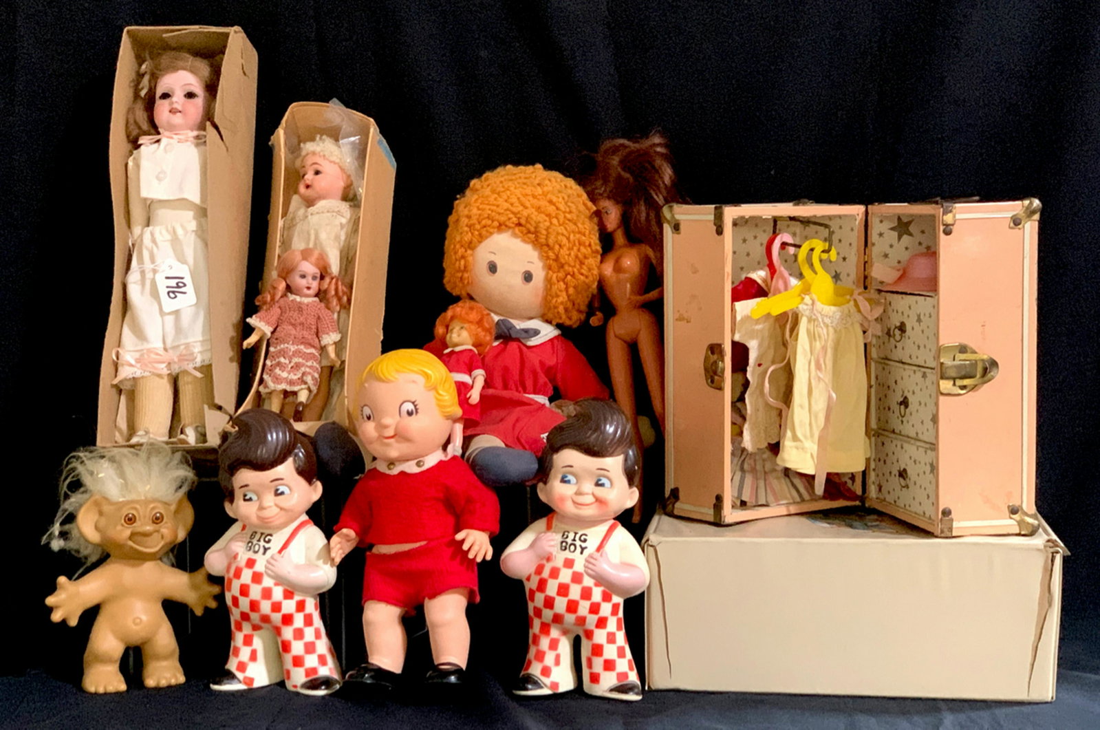 Group of 10 Dolls, Clothing and Trunk: 2 rubber Bob's Big Boys, 1 Raggedy Ann, 1 troll, 1 rubber Campbell's Soup kid with box, 1 Barbie, 3 vintage German bisque head dolls with 2 having boxes and a small Little Orphan Annie doll, good cond