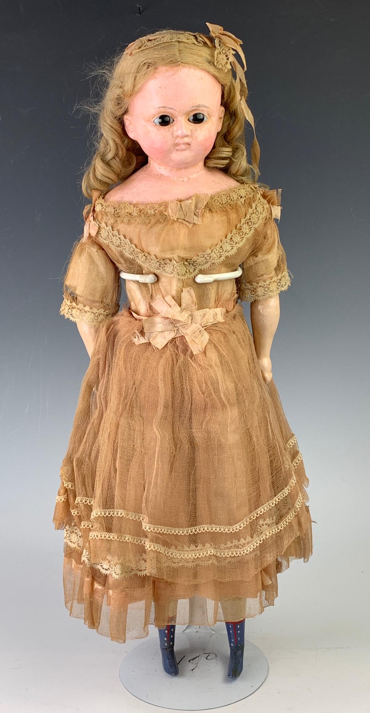 19" German Wax Over Papier Mache Shoulderhead: C. 1860's, dark brown glass eyes, original blond mohair wig, cloth body with composition lower arms, wooden lower legs, carved blue boots, clothing and undergarments all original, including hair ornam