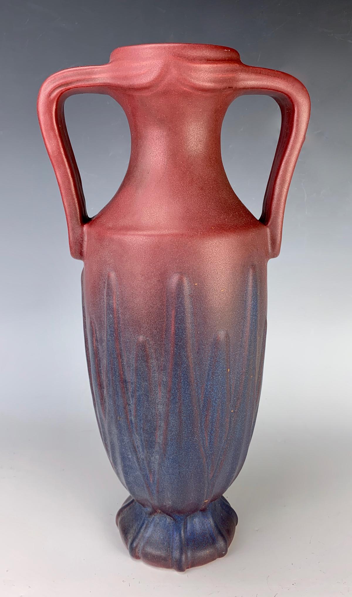 Tall Van Briggle (US 1922-1926) Handled Yucca Leaf Vase: Revealing yucca leaves under a mulberry glaze, incised "Van Briggle, USA" with factory logo, good condition, small nick on bottom underside of vase, 13.375" height