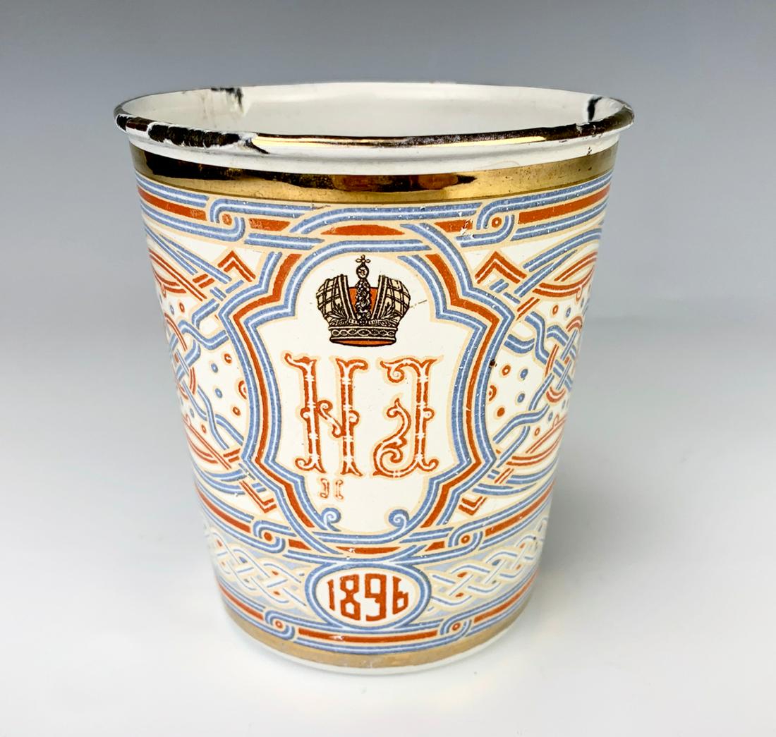 Russian Nicholas II 1896 Coronation Beaker: An enamel beaker with traditional interlace pattern, crowned monogram of Emperor Nicholas II and Empress Alexandra, offficial insignia of the Russian State and date 1896, overall good, a few chips, 4"