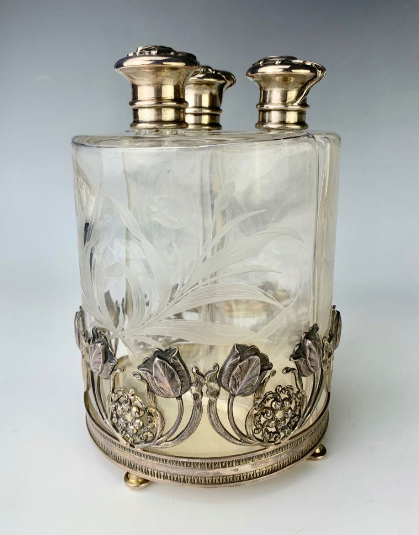 Art Nouveau Sterling 3 Section Perfume Bottles: Having 3 carved crystal bottles with sterling tops and holder, bottles carved with flowers and leaves and the sterling tops as well as base are decorated with flowers in relief, marked on bottom \"Ste