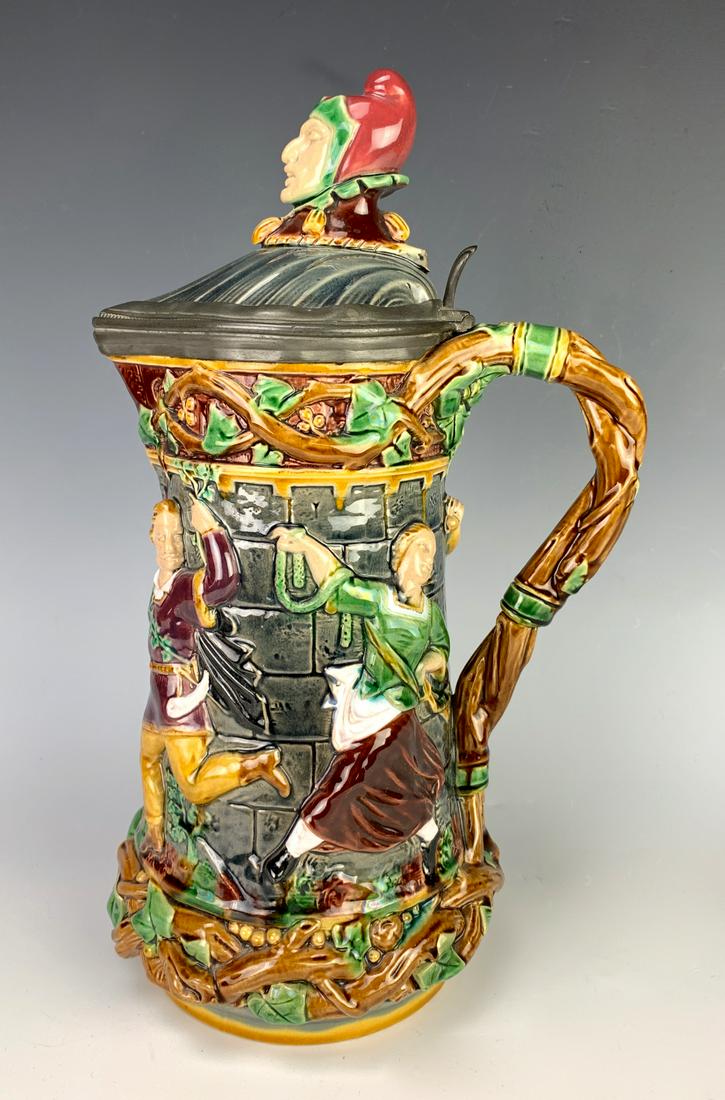 Minton Jester Figural Majolica Pitcher: Body of pitcher has raised scenes of dancing figures in mulit-colors, good condition, small chip missing from top lid, 13" height