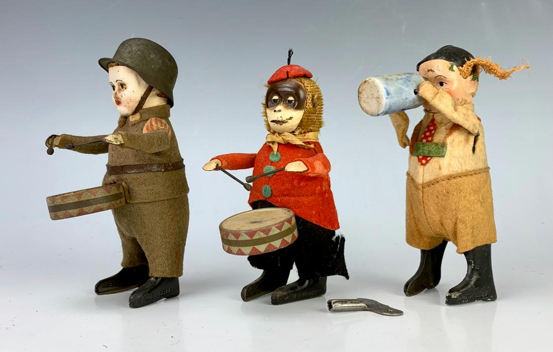 3 Schuco Wind Up Toys: Marked "Schuco Patent" and "Made in Germany", German soldier playing the dumbs, monkey playing drums and girl drinking beer, good condition with wear commensurate with age and use, working, comes with