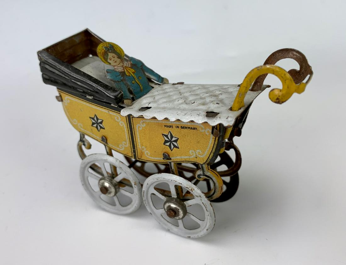 German Antique Penny Toy Baby in Carriage: Nice early German embossed lithographed tin penny toy "Baby in Carriage", very good condition, 2.5" height **Lifetime estate collection of Jeannine Hamilton, Oak Park, CA** *Domestic in-house shipping
