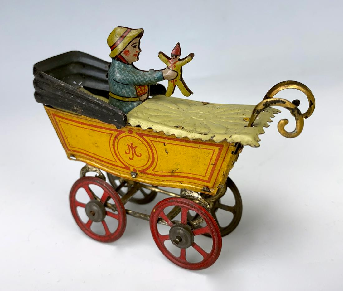 German Antique Penny Toy Baby in Carriage: Nice early German embossed lithographed tin penny toy "Baby in Carriage", baby holding up toy, very good condition, 2.5" height **Lifetime estate collection of Jeannine Hamilton, Oak Park, CA** *Domes