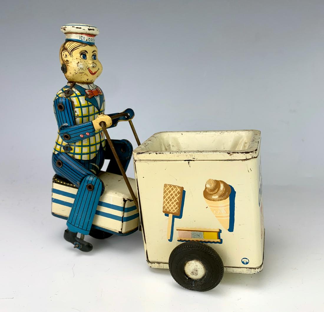 Japanese Tin Toy Ice Cream Vendor Truck: Tin lithographed embossed friction toy of an ice cream vendor with his ice cream truck, manufactured by K Toys - Japan, good condition, 5.5" height **Lifetime estate collection of Jeannine Hamilton, O