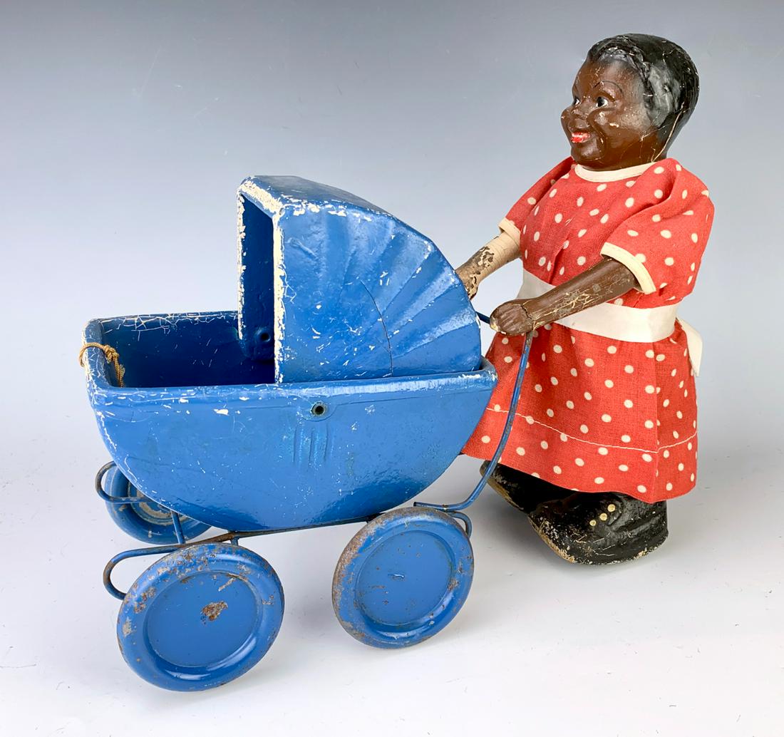 Black Americana "Girl Pushing Carriage" Pull Toy: Carriage has a string to pull carriage while the girl shuffles, good condition, minor paint wear commensurate with age, 9.5" height **Lifetime estate collection of Jeannine Hamilton, Oak Park, CA** *C