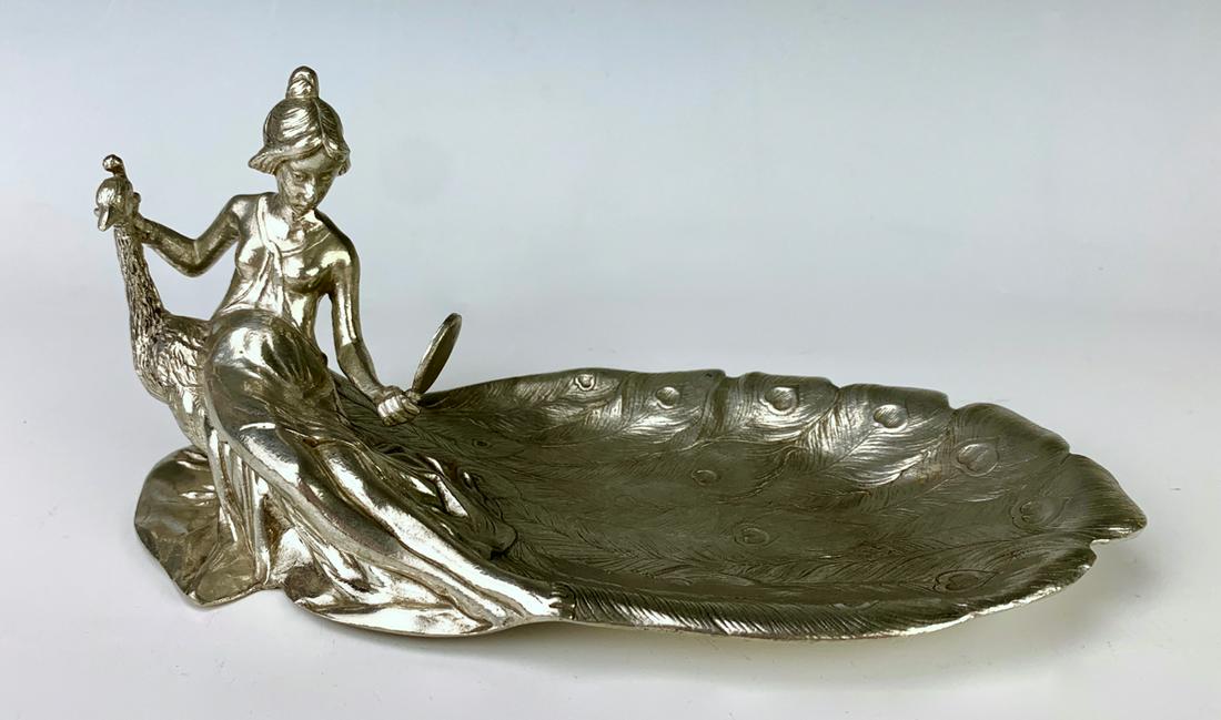 Peacock & Lady Vide Poche in Silver Gilt Metal: Depicts a woman peering into a hand mirror while petting a peacock whose feathers form the dish, has markings on bottom "Made in Italy Zinn 95% T" with spread winged bird logo, very good condition, 3.