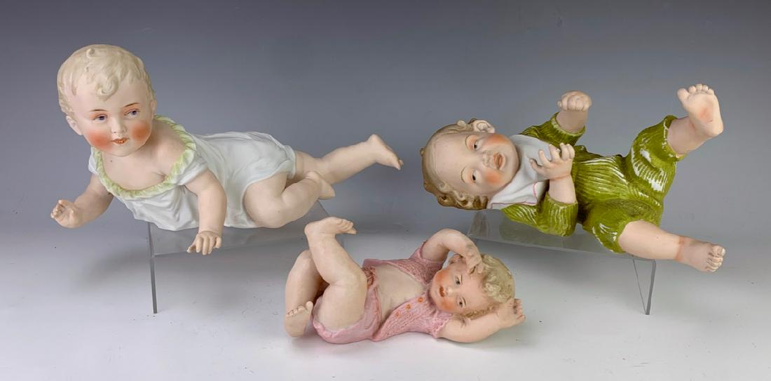 Group of 3 Antique Large Bisque Piano Babies: Wonderful group of 3 large piano babies, one with green outfit and one with white outfit, both not marked, piano baby with pink outfit signed Heubach, very good condition, 6.5" x 12" **Lifetime estate