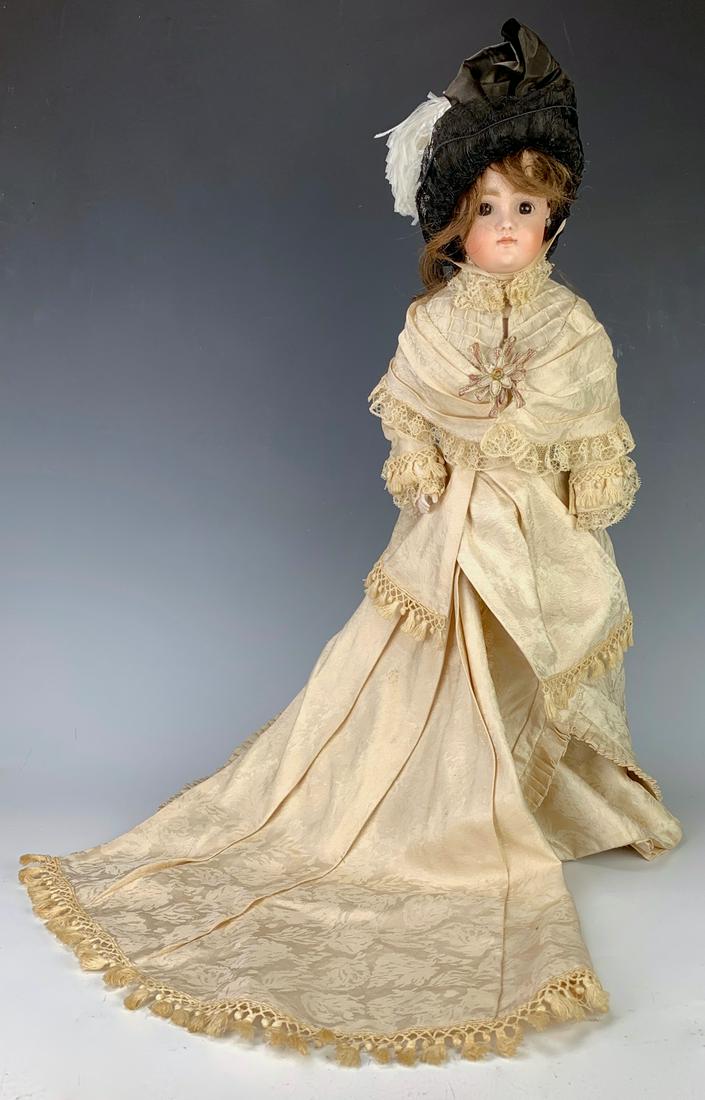 JD Kestner German Fashion Doll: Bisque swivel head on bisque shoulderplate, set brown glass eyes, leather German fashion body with bisque lower arms, marked on head "7", beautiful expertly made gown of antique silk, original wig wit