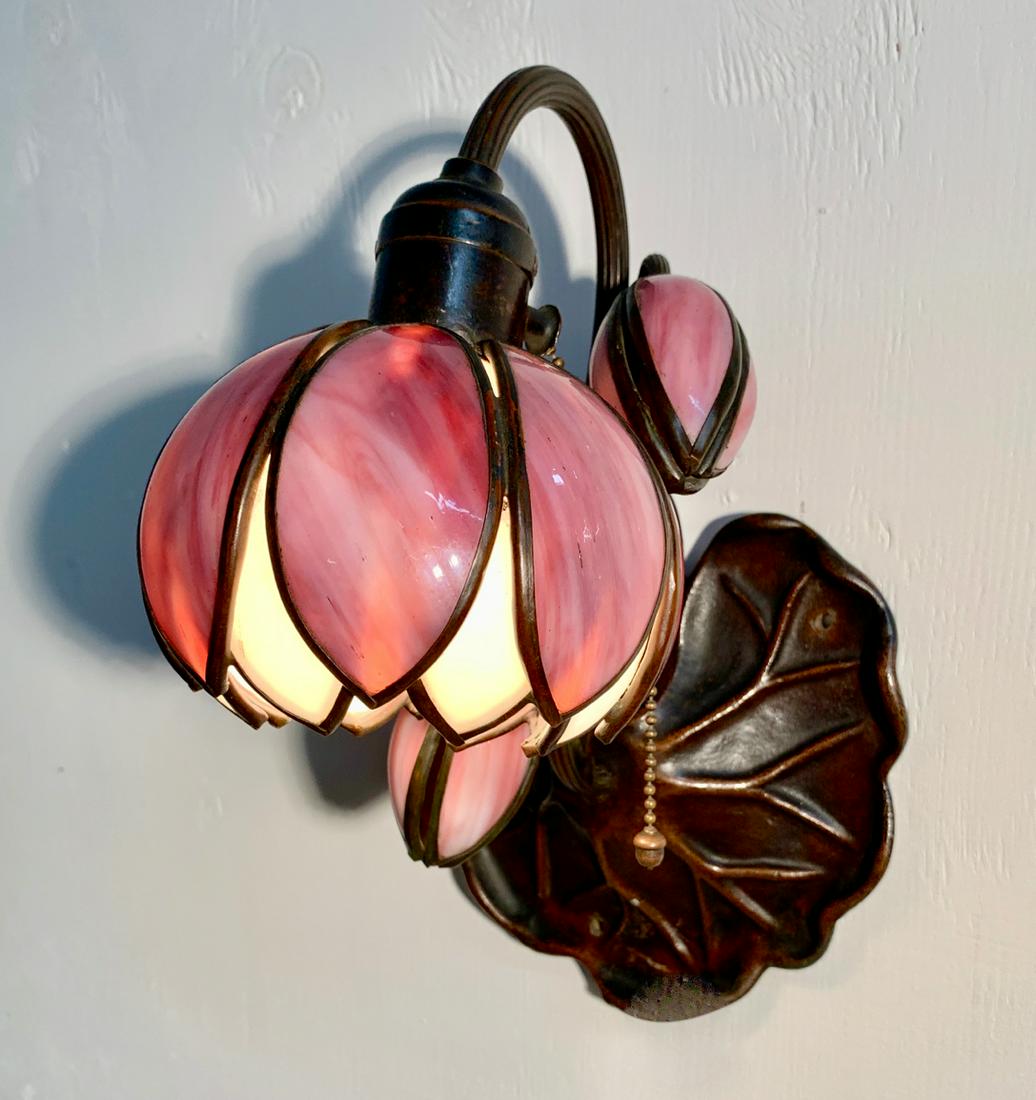 Rare Signed Handel Lily Pad & Lotus Sconce: Very rare lily pad and lotus flower stained glass wall sconce, having 3 arms with one red and white lotus shade and pods, attached to a lily pad wall sconce, back of lily pad signed with raised letter