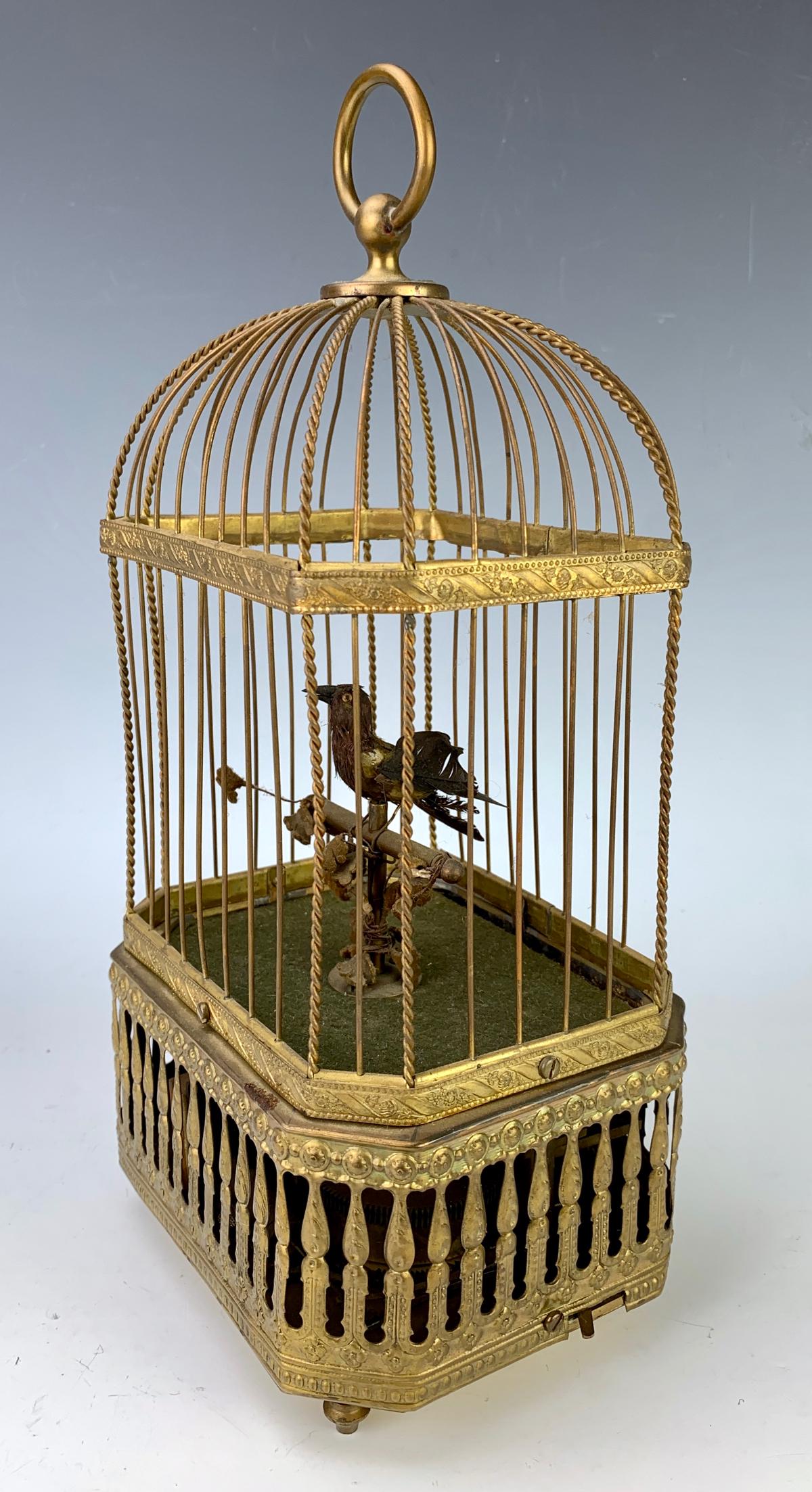 Antique German Mechanical Singing Bird in Cage: Circa 1900, consisting of a feathered bird on a perch that sings when wound, inside a gilt metal cage, marked "Made in Germany", key wound, working at time of auction, 12" height