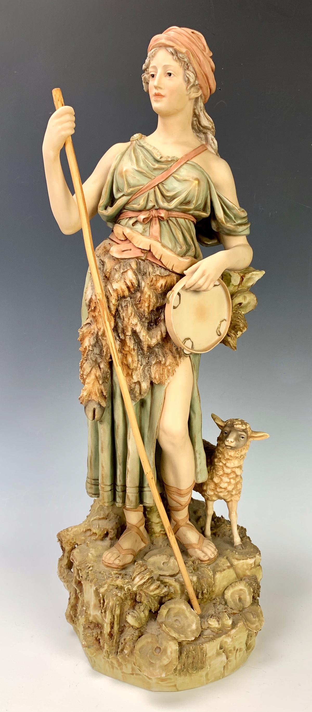 Royal Dux Shepherdess and Lamb Figurine: Having a tall figurine in porcelain of a shepherdess and her lamb standing on a rocky mound, marked "Royal Dux" with pink triangle, very good condition, 19.25" height
