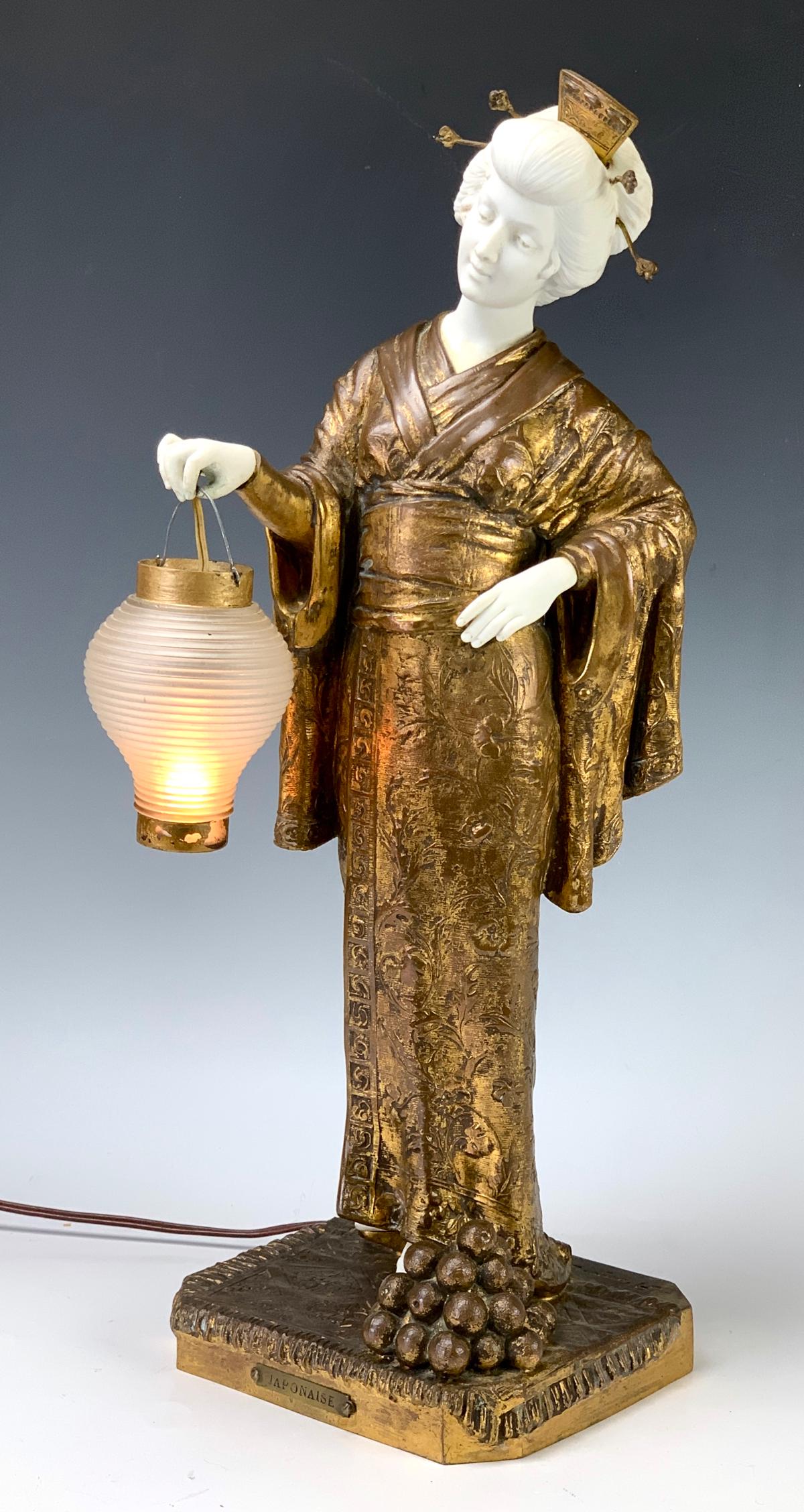 Dominique Alonzo (1910-1930) Japanese Lady w/Lamp: Wonderful figural lamp of a Japanese lady wearing a kimono holding a glass lantern which works, she is made of gilt spelter while her head, hands and feet are bisque porcelain, signed on the back "Alo